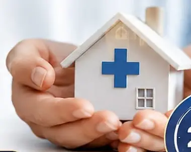 Caring hands holding a small house with a medical cross, representing home healthcare by 24 Life Home Care Private Limited